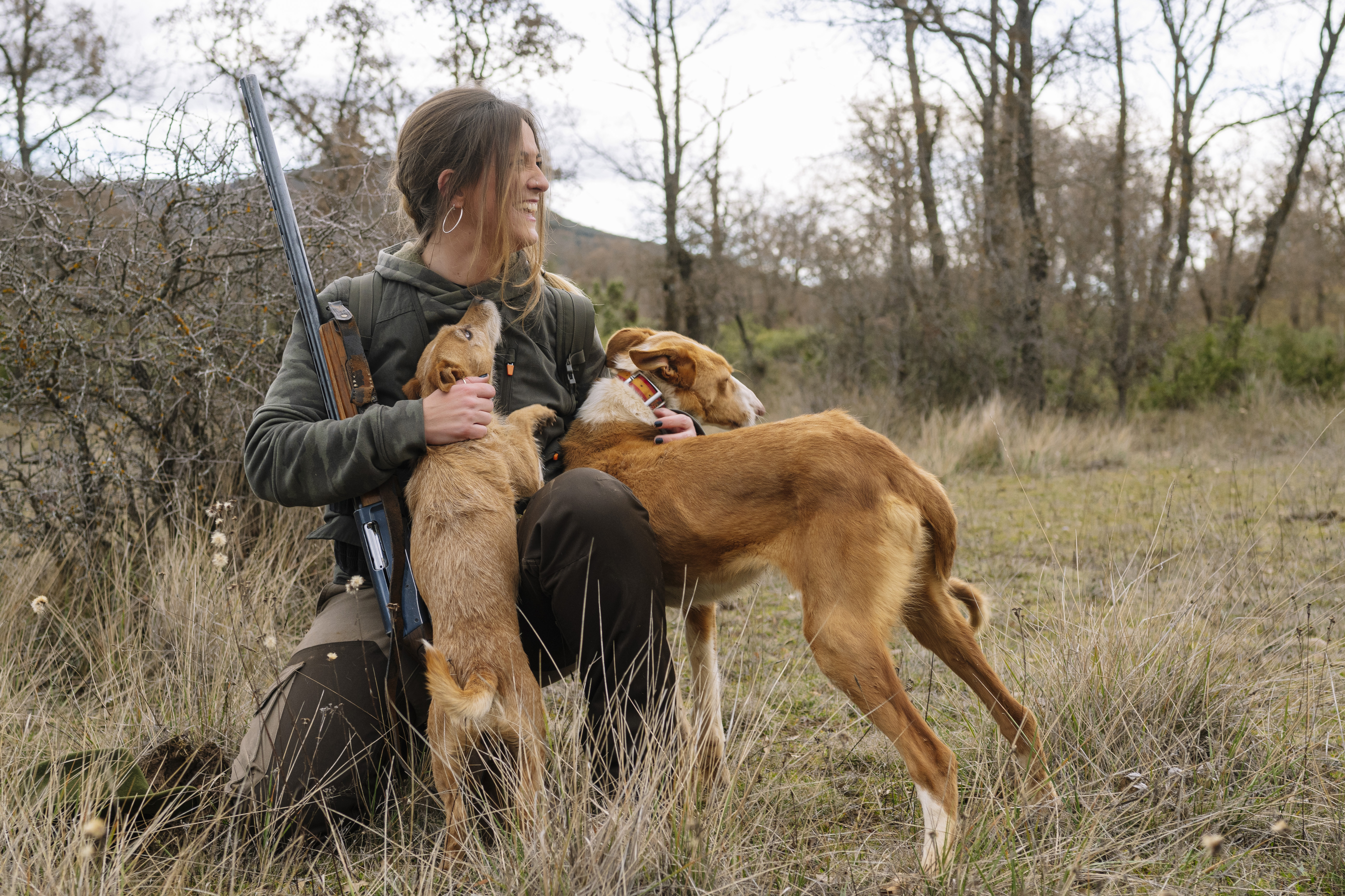 Cazadora con perros de caza en campo extremeño. Pienso Europremezclas.